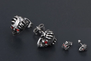 Détail des boucles d'oreilles tête de mort punk avec yeux rouges et finition argent vieilli
