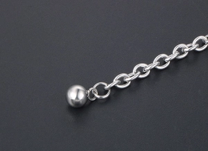 Macro detail of silver adjustable chain extender with polished metallic bead pendant