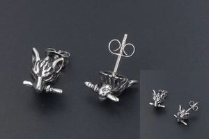 Detail shot of vintage punk wolf head earring with sword, stainless steel jewelry