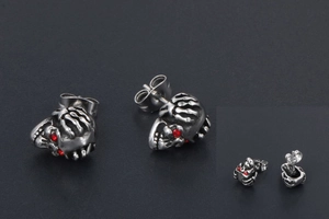 Détails de boucles d'oreilles tête de mort en acier inoxydable avec yeux en cristal rouge