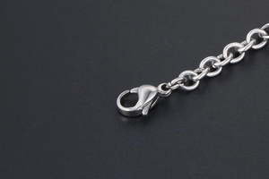 Detailed close-up of a high-quality silver lobster clasp and round links on a steel chain