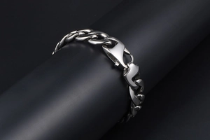 Macro view of polished silver titanium steel Cuban chain link bracelet with lobster clasp