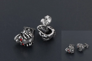 Détail de boucles d'oreilles tête de mort gothiques avec yeux en zircon rouge