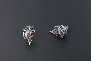 Macro view of vintage silver lion head earrings with sparkling red gemstone eyes