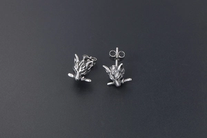 Macro shot of punk style wolf head earrings with antique silver finish and bone detail