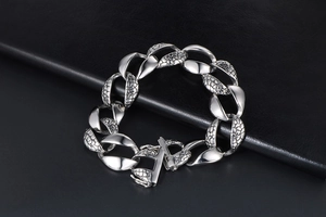 Detail of silver snake-patterned chain bracelet with polished finish and square clasp