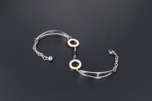Detail view of multi-tone stainless steel bracelet with rhinestones and black obsidian bead