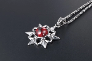 Detailed view of vintage silver hexagram pendant with a red gemstone on dark background
