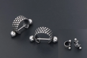 Macro view of vintage style titanium steel ear cuff with textured spherical relief patterns