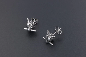 Detail view of retro wolf head stud earrings with sword design in vintage titanium steel