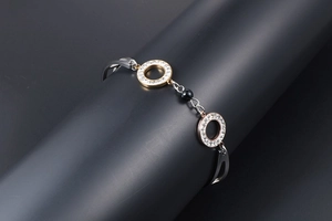 Macro view of rose gold bracelet featuring micro-pave crystals and a black obsidian bead