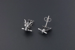 Macro detail of gothic wolf head stud earrings with vintage punk style sword motif