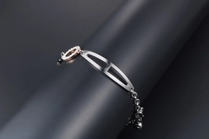 Detail of rose gold and silver bangle with H-shaped element and sparkling pavé crystals