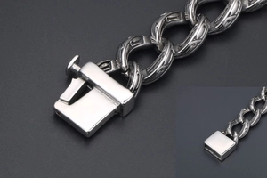 Dettaglio ravvicinato delle maglie incise retrò e della chiusura a scatola del bracciale