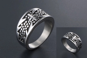 Macro shot of silver titanium steel cross ring with embossed polka dot textures and punk style