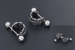 Gros plan de boucles d'oreilles couronne rétro avec gravures creuses et fermoir boule