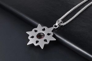 Macro detail of retro star pendant with red gemstone and silver wheat chain