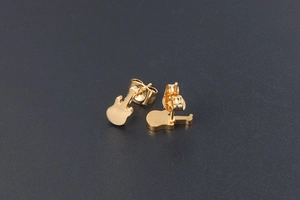 Detailed close-up of 24K gold plated titanium steel guitar stud earrings on textured background