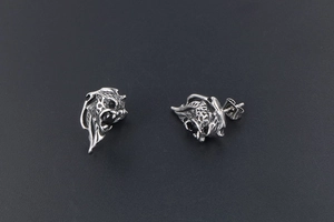 Detailed view of silver lion head earrings with black zircon eyes and vintage metal finish