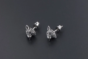 Macro detail of punk wolf head stud earrings made of vintage silver stainless steel