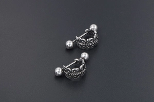 Gros plan sur des boucles d'oreilles barbell rétro avec motifs gravés et couronne