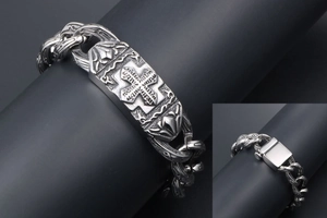 Dettaglio di bracciale punk vintage in metallo argento con croce incisa e chiusura