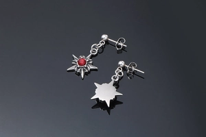 Détail macro d'une boucle d'oreille en acier avec une pierre rouge centrale