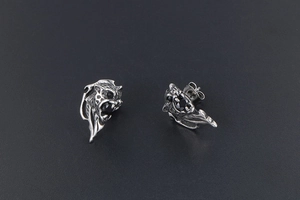 Detailed view of a silver lion head stud earring with black zircon inlays and carvings