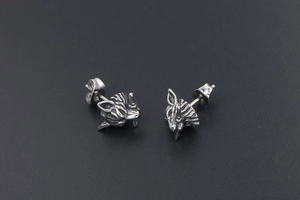 Macro detail of retro punk wolf head earrings with oxidized stainless steel texture