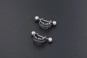 Détail macro du motif de vigne gothique gravé sur des boucles d'oreilles en acier argent