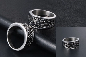 Detail of vintage steel ring featuring embossed cross pattern and beaded texture