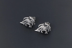Close-up of gothic lion stud earrings with hollow leaf pattern and black stone inlay