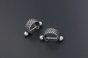 Macro shot of punk style titanium steel earrings with embossed dot texture detail