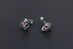 Détail macro de boucles d'oreilles crâne avec yeux en cristal rouge et fini vieilli