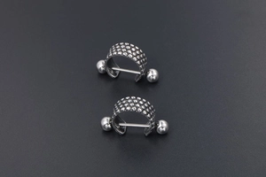 Detailed view of silver titanium steel punk earrings with textured ball relief pattern