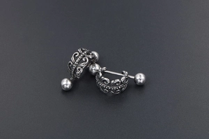 Détail macro de boucles d'oreilles en acier inoxydable avec motifs floraux rétro gravés