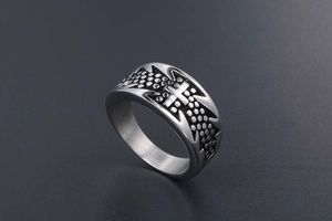 Macro view of vintage titanium steel cross ring with embossed polka dot textures