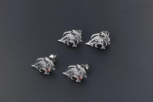 Macro detail of retro lion head stud earrings with red gems and antique silver finish