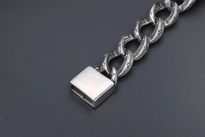 Dettagli macro di un bracciale a catena vintage in argento con incisioni e chiusura