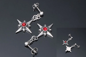 Dettaglio macro dell'orecchino a stella in acciaio al titanio con zircone rosso