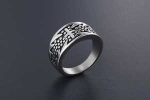 Macro shot of vintage cross ring with textured polka dot background and carved punk edges
