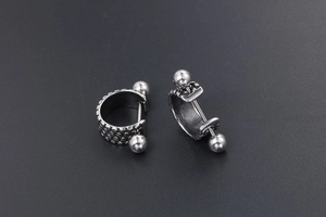 Close-up of punk style titanium steel hoop earrings with textured finish and metal beads