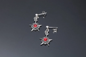 Gros plan sur les boucles d'oreilles étoile argentées avec pierres rouges punk