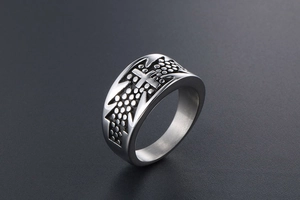 Macro detail of men's titanium steel ring featuring cross pattern and dotted texture