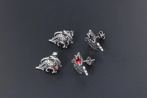 Close-up of gothic dragon stud earrings in stainless steel with red and black stones