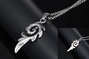 Détail macro du pendentif flamme tribale en argent avec étoile gravée et chaîne à billes
