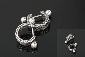 Macro shot of silver titanium steel earrings featuring woven chain texture and punk style