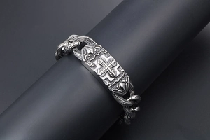 Dettaglio del bracciale da uomo in acciaio inossidabile con croce a rilievo e stile vintage