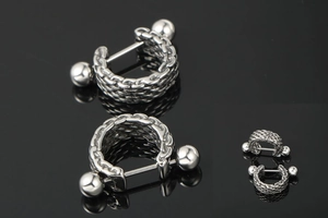 Macro view of silver titanium steel earrings with thick industrial chain link texture