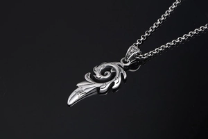 Détail du pendentif flamme vintage avec gravure d'étoile sur une chaîne rolo